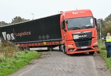 Vrachtwagen vast in sloot op landweg in Heukelom bij Oisterwijk