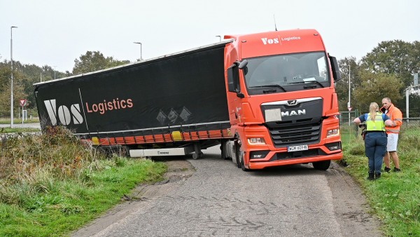 Vrachtwagen vast in sloot op landweg in Heukelom bij Oisterwijk
